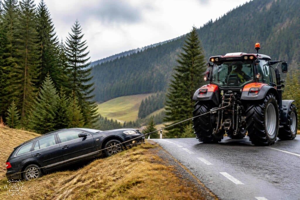 Auto mit Traktor zurück auf die Straße gezogen